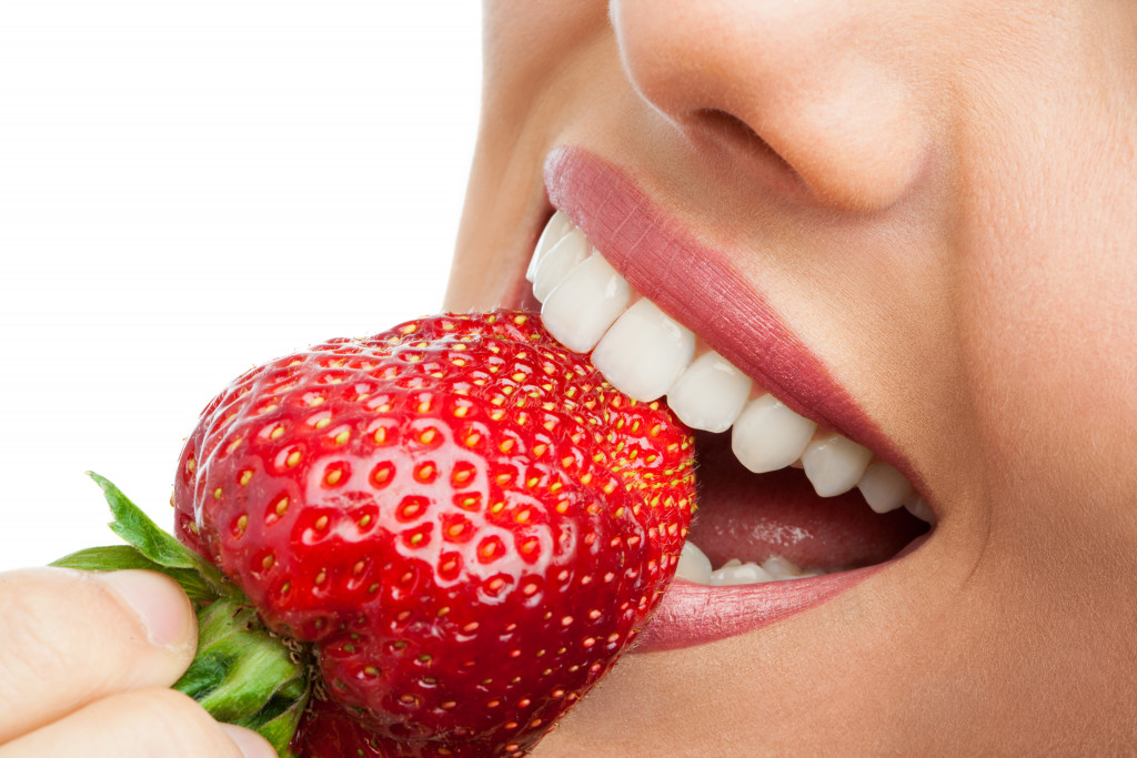 Close up of a woman eating a strawberry