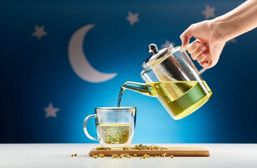 pouring chamomile tea from teapot into mug