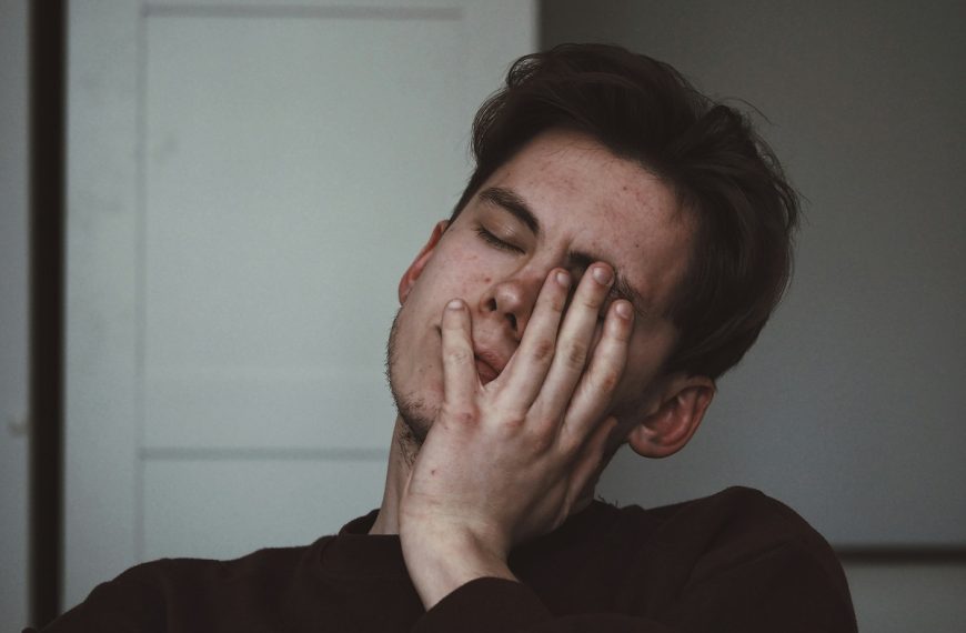 stressed man with his hand over his eye