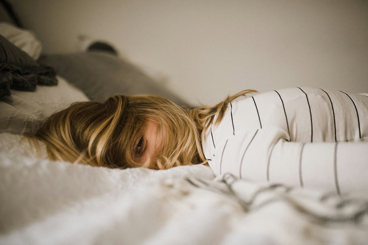 tired woman lying on a bed